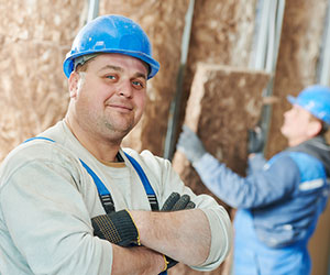 Insulation contractor installing fiberglass insulation